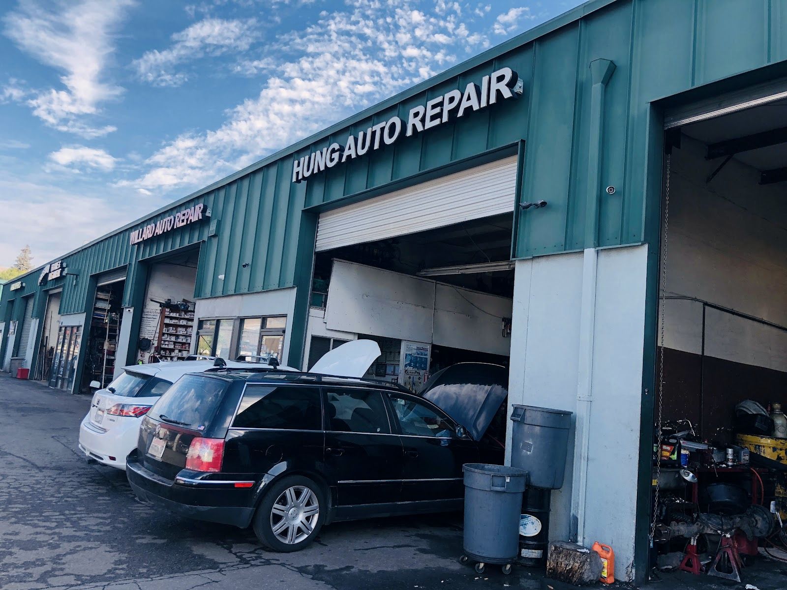 The Hung Auto Repair garage on S Capitol Ave, bay door up, cars waiting